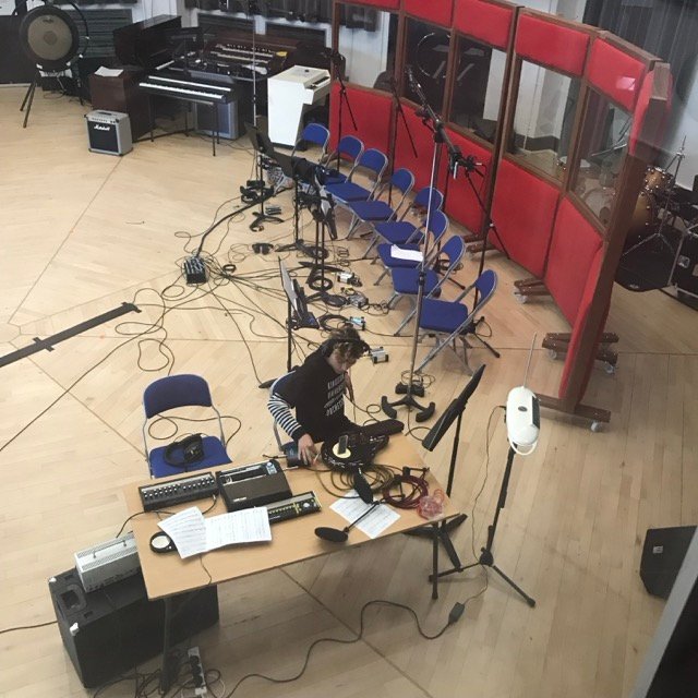 Overhead view of a recording session in progress, with microphones, chairs and stands set out for an ensemble.